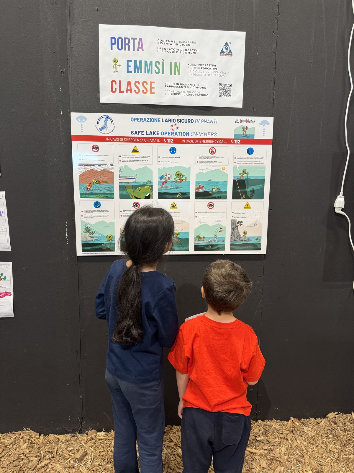 Due bambini guardano il cartellone di Operazione Lario Sicuro ad Agrinatura 2026
