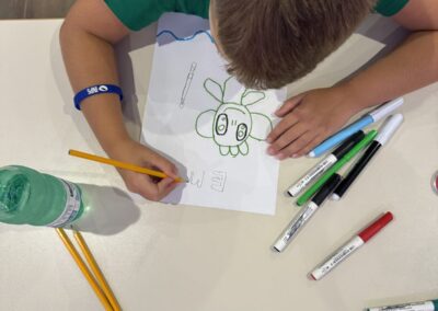 Un ragazzo disegna Emmsì al laboratorio